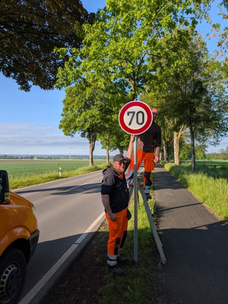 Die Straßenwärter Alexander Buchholz und Michael Brüntrup (v.l.) bringen die neuen 70 km/h-Schilder an der K37 an. © Timm, Rosenthal - Kreis Paderborn